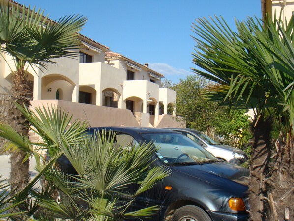 A building with multiple balconies and arched windows, surrounded by palm trees. - Apartment/ flat - CALVI (Calvi)