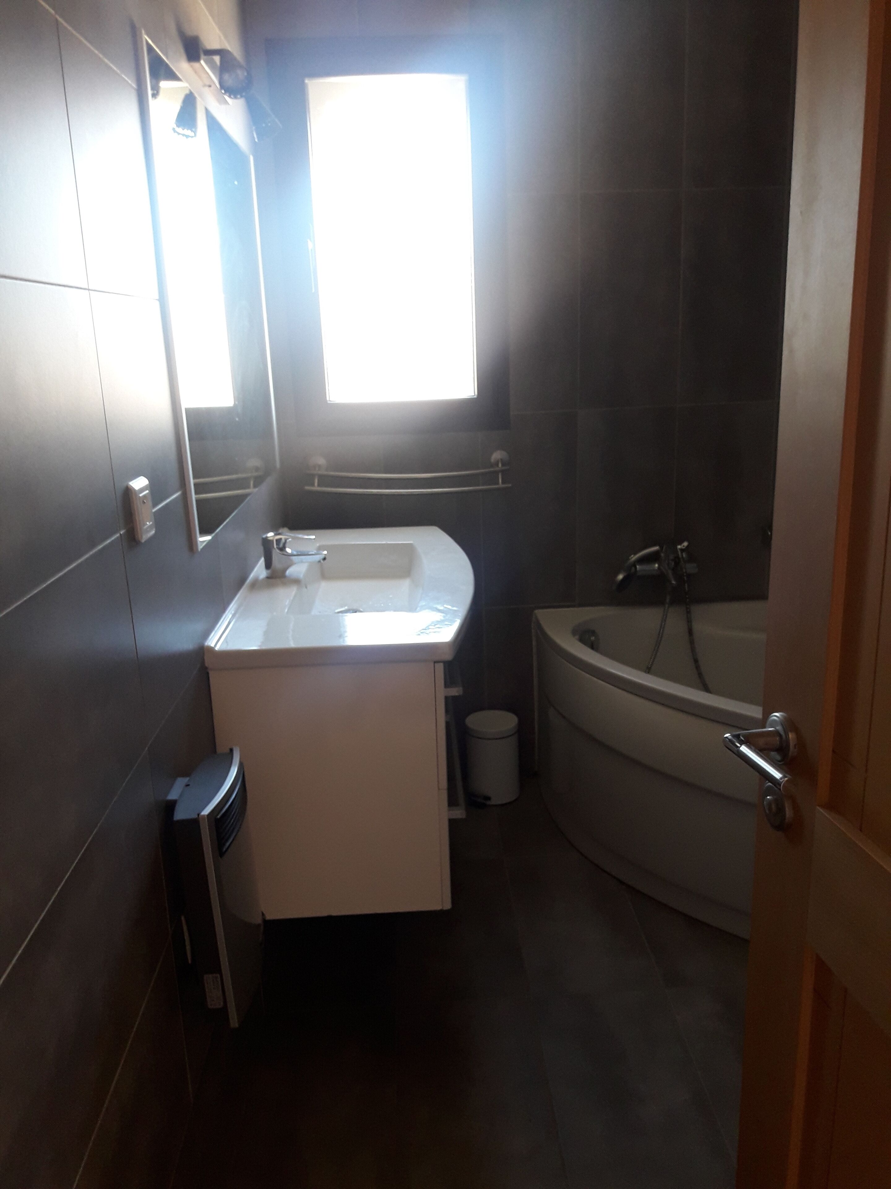 A modern bathroom with a built-in sink, vanity, and bathtub.