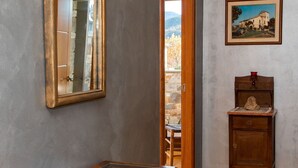 A room with a wooden cabinet, a glass-top table, a framed painting, and a mirror on the wall. - Beautiful  villa for 14 guests with private pool, WIFI, TV, terrace and pets allowed (La Seu D'urgell)