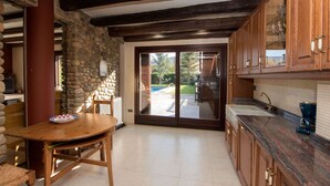 A kitchen with stone walls, wooden beams, and a view to the outside. - Beautiful  villa for 14 guests with private pool, WIFI, TV, terrace and pets allowed (La Seu D'urgell)