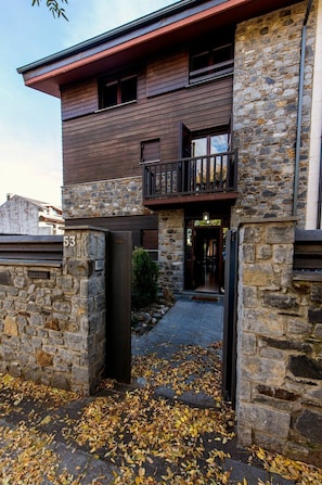 A two-story building with a stone facade and a balcony.