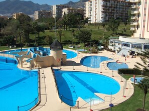 A large outdoor swimming pool complex with multiple pools and a central tower structure.