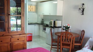 A compact room with a bed, a small dining table, and a kitchenette. - A beautiful studio apt overlooking pools ' Minerva.Jupiter @ Bonanza Square ' (Benalmadena)