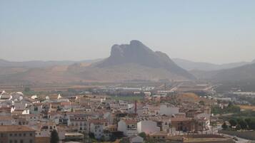 Un pueblo con edificios blancos y una colina destacada al fondo.
