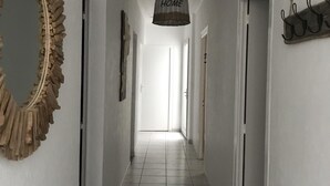 Un pasillo con un espejo, un letrero que dice 'HOME' y un perchero.