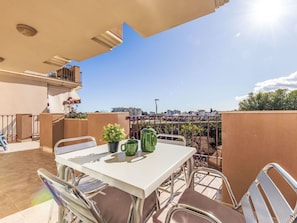 Une terrasse sur le toit, avec une table, des chaises et une vue sur le paysage urbain.