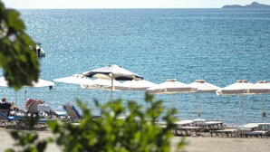 Una playa con sombrillas y sillas de descanso.