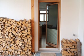 A doorway leading to a room with a wooden door and a glass panel.