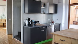 A modern kitchen with black cabinetry, a wooden countertop, and a built-in dishwasher. - Central holiday home in the countryside for families with and without pets (Murnau am Staffelsee)