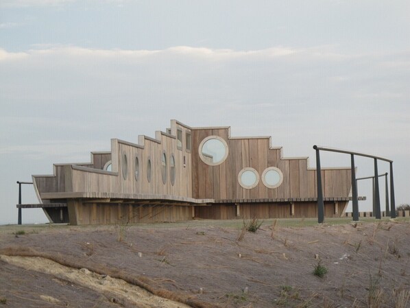 A wooden building with circular windows and a ramp.