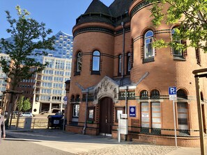En historisk bygning med en markant indgang, et skilt for politistation og et parkeringstegn.