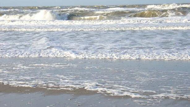 A beach with waves crashing onto the shore.