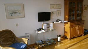 A living room with a television, a cabinet, and a chair.