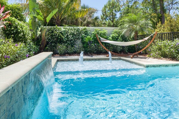 A swimming pool with a hammock and a waterfall feature. - Beautiful Holiday House at Paradise Coast in Naples / FLorida (Naples)