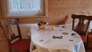 A wooden-paneled room with a table covered by a tablecloth featuring butterfly patterns and Latin text.