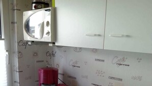 Une petite cuisine équipée d’une machine à café, d’un grille-pain et d’une bouilloire, le tout posé sur le plan de travail.