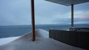 A snow-covered deck with a view of the ocean and a distant mountain range. - Wonderful holiday house on the Nollur farm at Eyafjord (Akureyri)