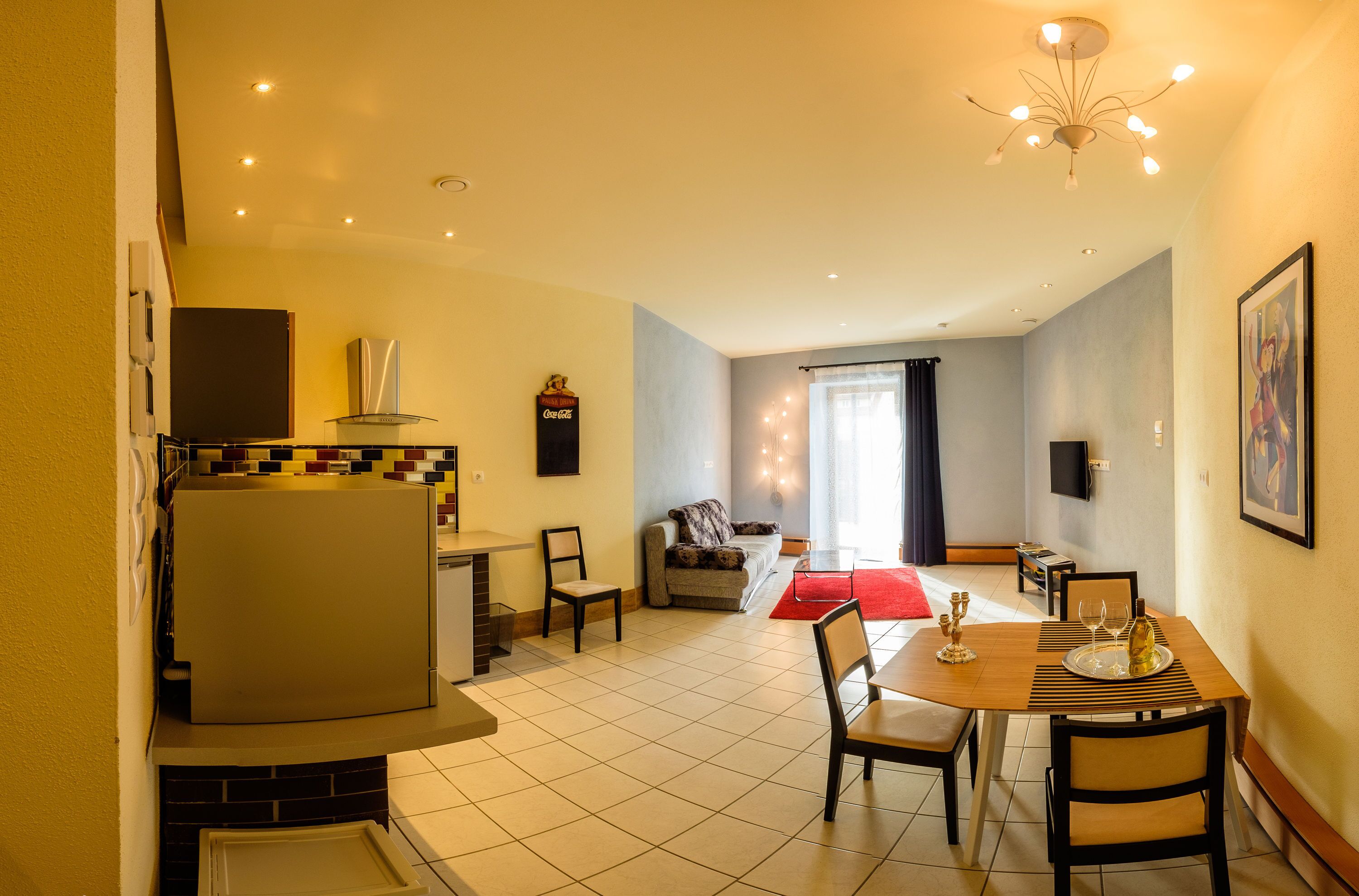 A compact living space with a kitchenette, dining area, and seating area.
