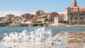 A waterfront view with buildings and a splash of water.