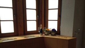 A corner window seat with a white rug, a bottle of champagne, two glasses, and small flower pots. - Holidays in the idyllic wine-growing village near Freinsheim (Bobenheim am Berg)