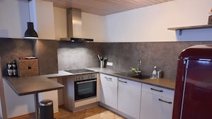 A modern kitchen with a built-in oven, a sink, and a stainless steel refrigerator. - Holidays in the idyllic wine-growing village near Freinsheim (Bobenheim am Berg)