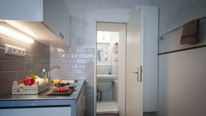 Cocina pequeña con encimera, fregadero y un espacio de almacenamiento.
