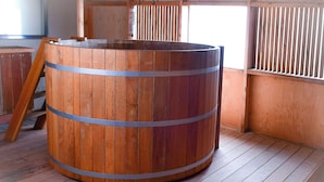 A wooden barrel with metal bands, placed on a wooden floor in a room with wooden walls and a window. - Loft house with incredible views of the fjord (Akureyri)