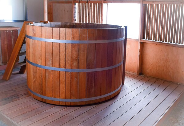 A wooden barrel with metal bands, placed on a wooden floor in a room with wooden walls and a window. - Loft house with incredible views of the fjord (Akureyri)