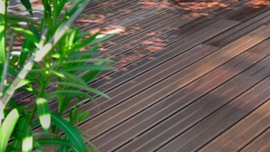 Une terrasse en bois avec un pot de fleurs.