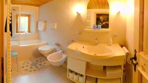 A bathroom with a bathtub, toilet, bidet, and sink. - Holiday home in quiet and sunny location. Perfect for families and friends. (Südtirol)