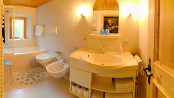Ein Badezimmer mit Badewanne, Toilette, Bidet und Waschbecken.