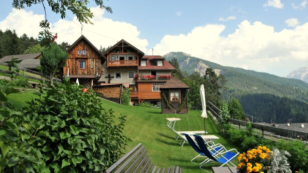 A wooden chalet with a balcony, a small garden, and mountain views. - Holiday home in quiet and sunny location. Perfect for families and friends. (Südtirol)