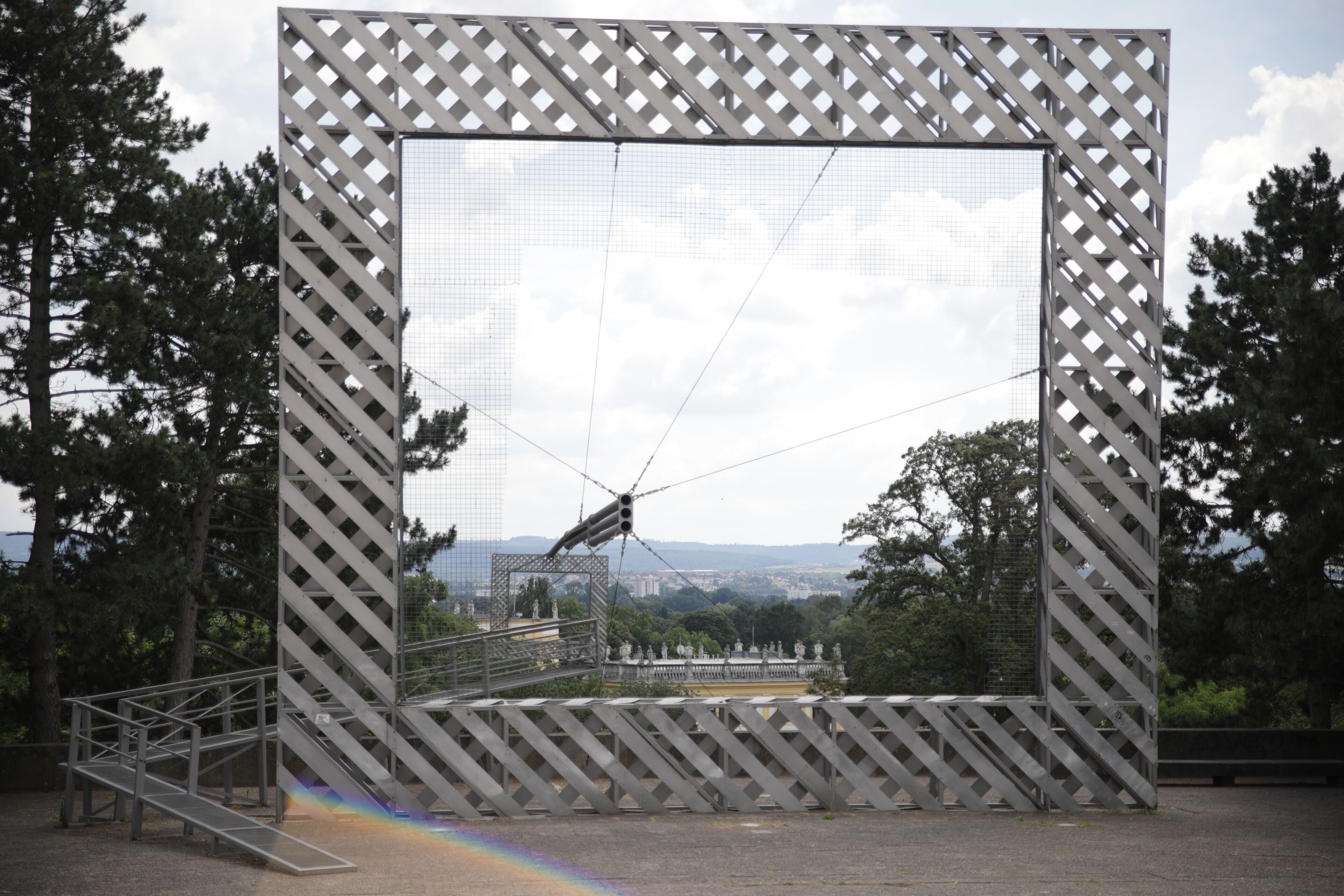 Una gran estructura metálica con diagonales de refuerzo, una escalera de metal y vistas a un paisaje lejano.