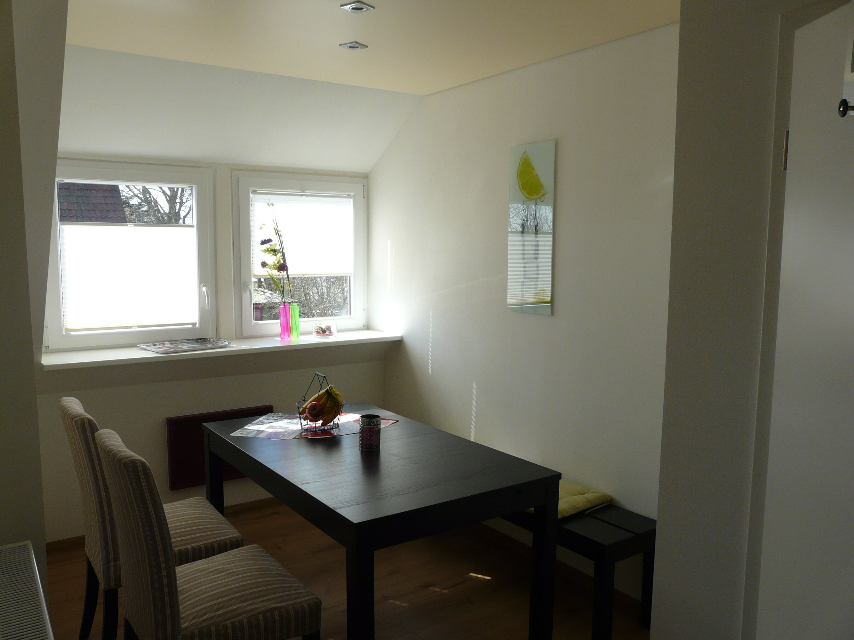 A room with a window, a table, and a chair.