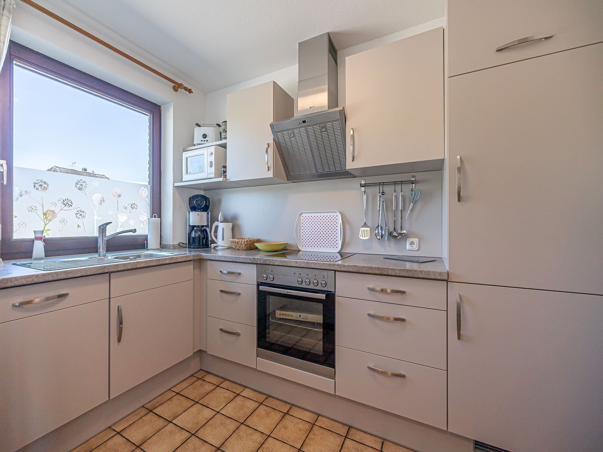 A compact kitchen with a built-in oven, a microwave, and a coffee maker.