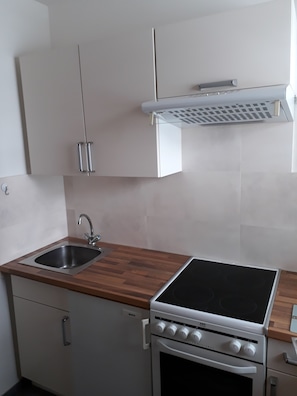 A kitchen with a Bosch stove, a sink, and white cabinets.