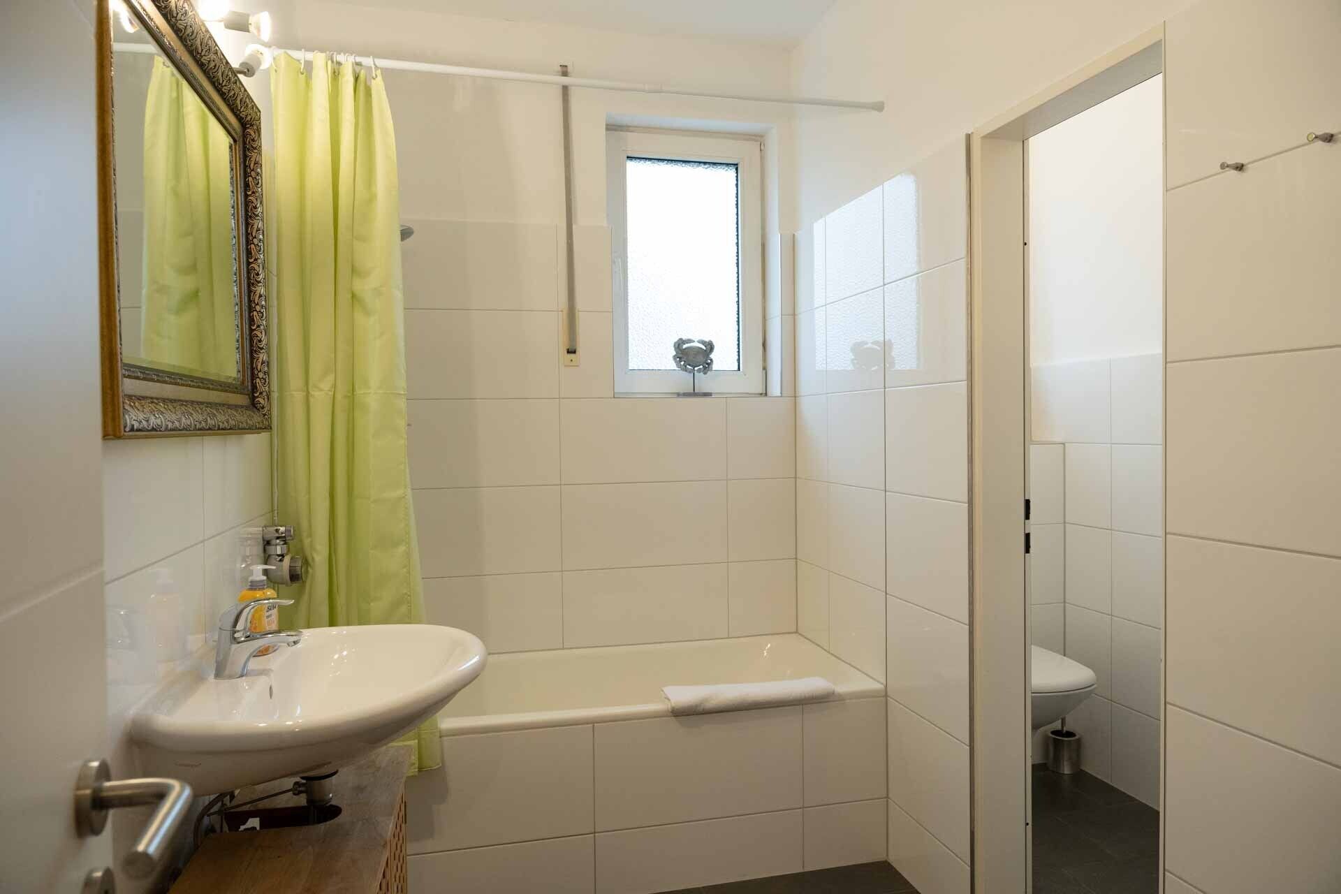 Un baño con un lavamanos blanco, una bañera y un inodoro.