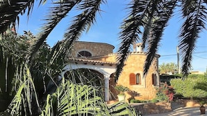 Un bâtiment à la façade incurvée, doté d’une piscine et bordé de palmiers.