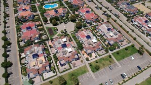 An aerial view of a residential area with multiple houses, a swimming pool, and a parking lot. - Living room with balcony and sea view, waterfront and south-facing (Vera)