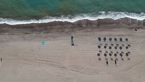 An aerial view of a beach with a circular arrangement of objects, possibly for a specific activity or event. - Living room with balcony and sea view, waterfront and south-facing (Vera)