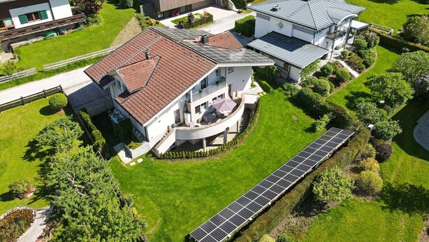 Un quartier résidentiel avec des maisons modernes, des panneaux solaires et des pelouses bien entretenues.