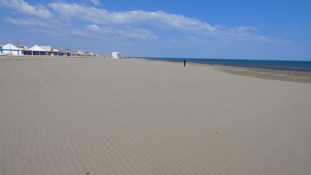 A wide sandy beach with a few buildings in the background. - Beautiful, lovingly furnished holiday home near the beach with sea views (Narbonne)