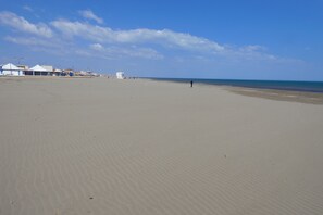 A wide sandy beach with a few buildings in the background. - Beautiful, lovingly furnished holiday home near the beach with sea views (Narbonne)
