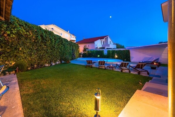 A backyard with a swimming pool, lounge chairs, and a well-maintained lawn. - Apartment in Vodice with Seaview, Terrace, Air condition, WIFI (94-7) (Vodice)