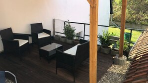 A covered outdoor seating area with wicker furniture and potted plants. - Centrally located for Harz visitors, fair guests, fitters, Alfeld (5min), Leineberg (Alfeld (Leine))