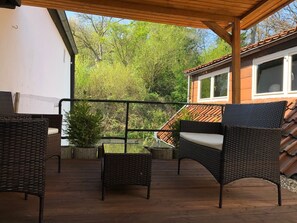 A covered outdoor area with wicker furniture and a view of trees and a building. - Centrally located for Harz visitors, fair guests, fitters, Alfeld (5min), Leineberg (Alfeld (Leine))