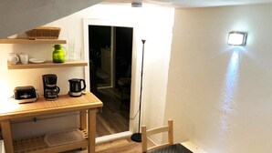 A small kitchen with a wooden table, a coffee maker, and a toaster. There is a shelf with cups and a green pitcher. - Centrally located for Harz visitors, fair guests, fitters, Alfeld (5min), Leineberg (Alfeld (Leine))