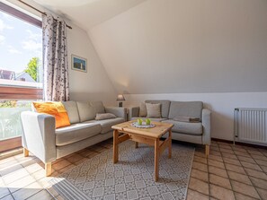 Un salon confortable avec un canapé, une table basse et une lampe.