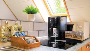 Eine Küche mit einer Kaffeemaschine, einer Mikrowelle und einer Holzkiste mit Aufschrift.