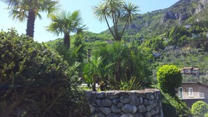 Un muro de piedra con vistas a una ladera con casas y vegetación.